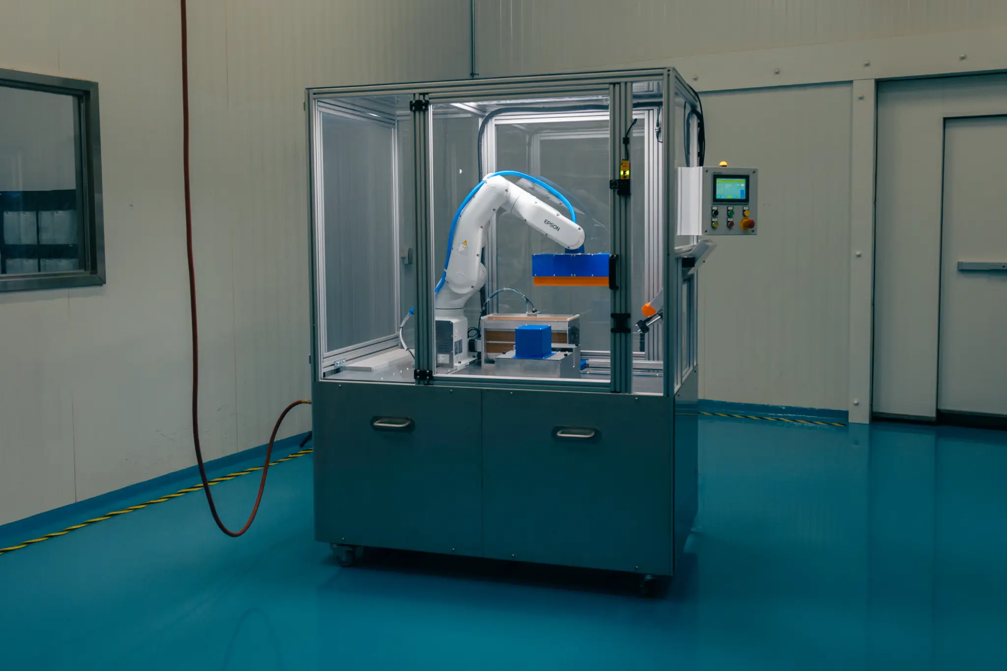 The complete Nu-Tec automated coating machine in its enclosed production cell